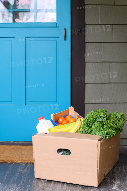 Box of delivered produce on house porch