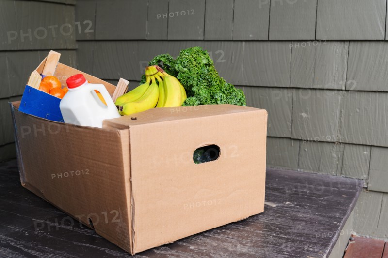 Box of delivered produce on house porch