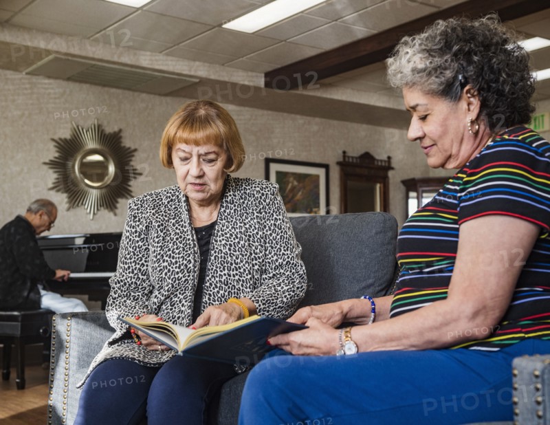 Senior women looking at album