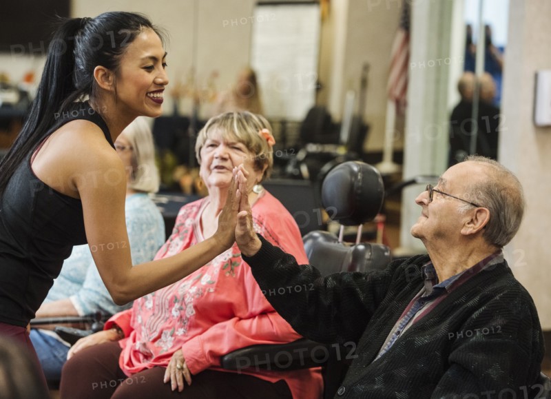 Senior man high-fiving fitness instructor