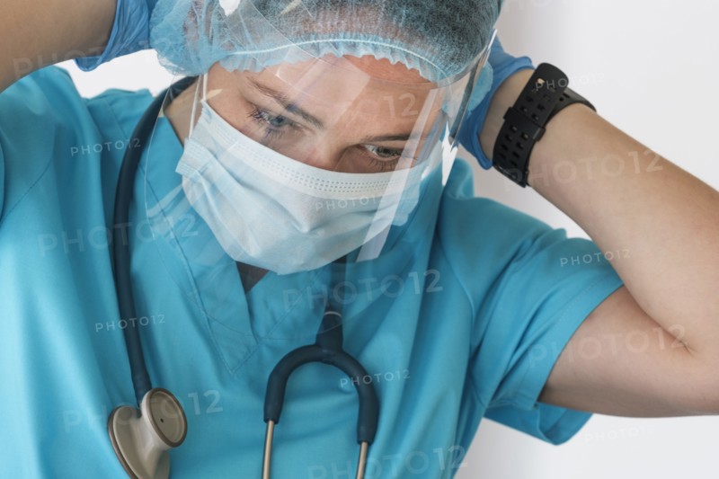 Nurse putting on face shield