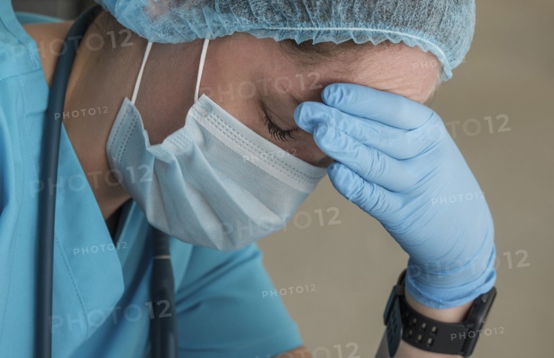 Nurse in face mask experiencing symptoms