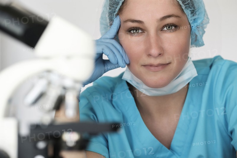 Portrait of laboratory technician next to microscope