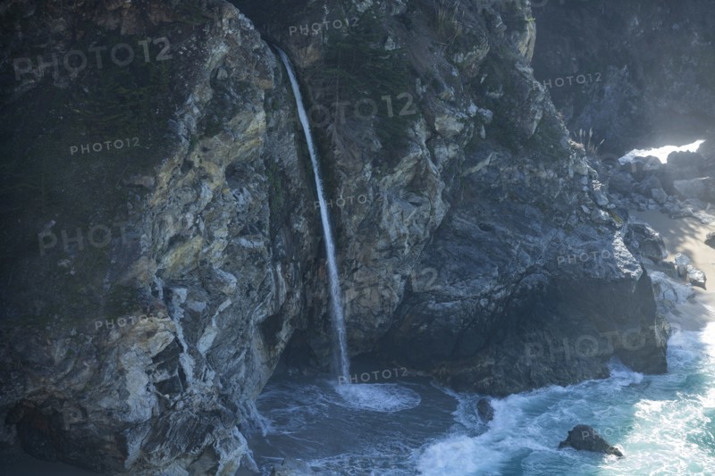USA, California, Big Sur, Waterfall falling from cliff at sea side