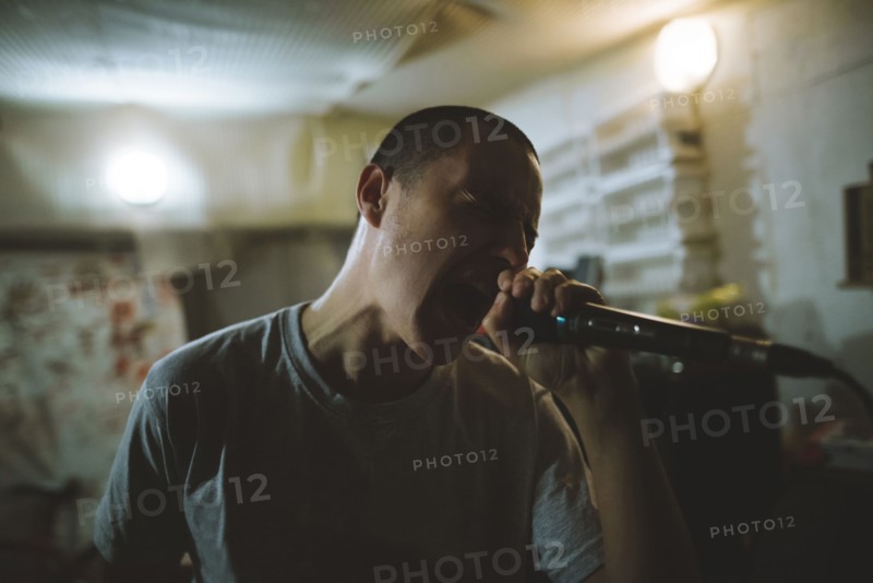 Young man singing during rehearsal in garage