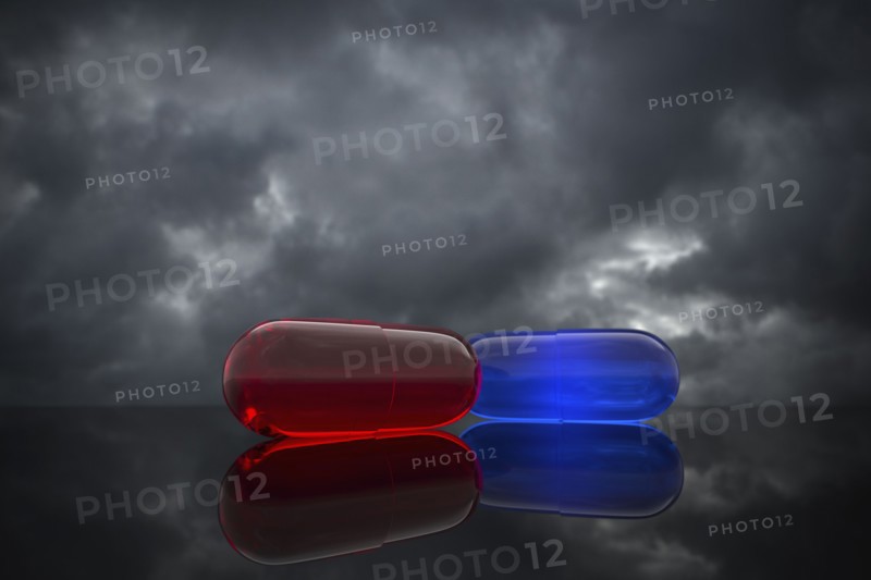 Red and blue pills on cloudy background