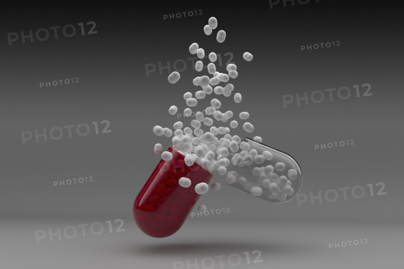 Studio shot of red capsule with white pills inside