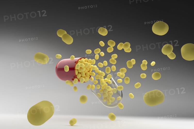 Studio shot of capsule with yellow pills inside