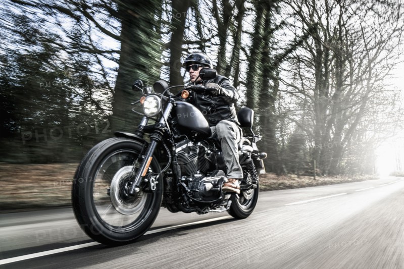 United Kingdom, London, Motorcyclist on road in forest