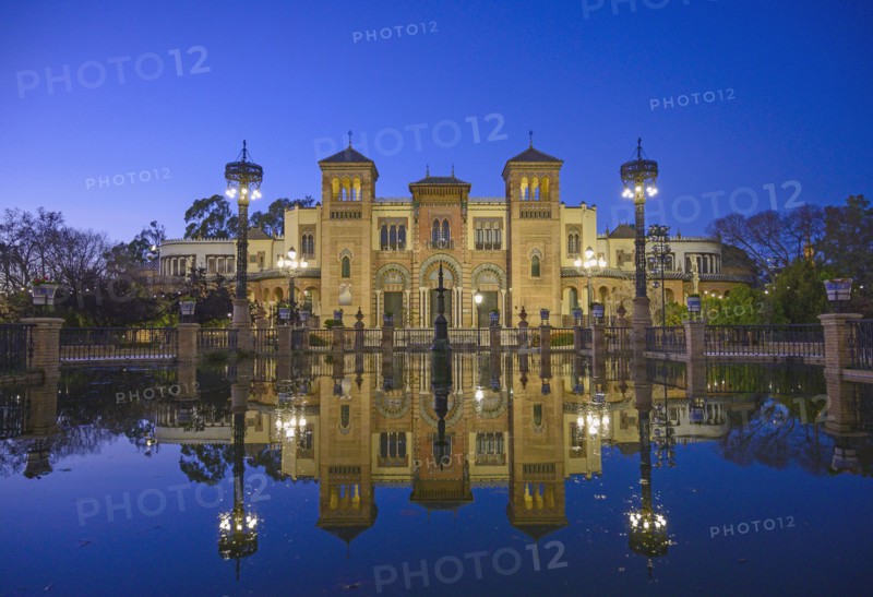 Spain, Seville, Museum of Arts and Popular Customs of Seville reflecting in pond