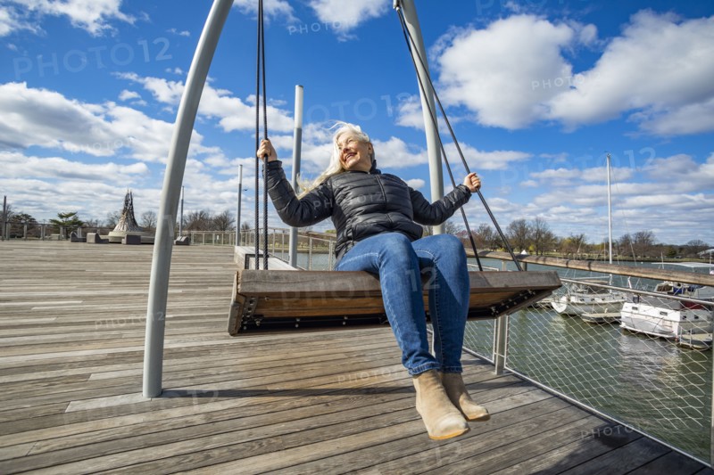 USA, Washington D.C., Senior woman on swing at Wharf District along Potomac River