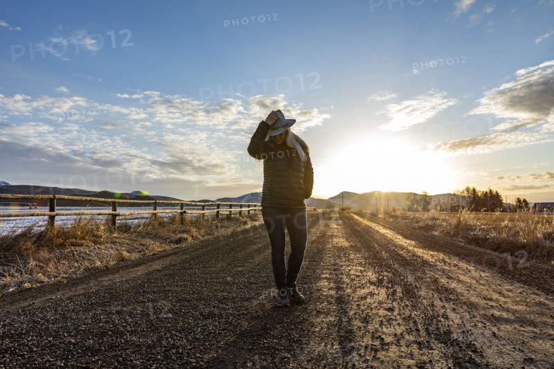 USA, Idaho, Sun Valley, Woman at sunrise on rural road