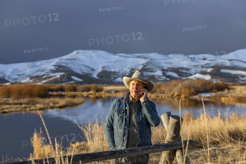 USA, Idaho, Sun Valley, Senior man in cowboy using smartphone