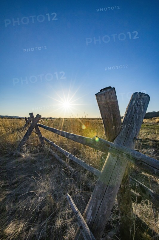 USA, Idaho, Picabo, Wooden fence in rural area at sunset