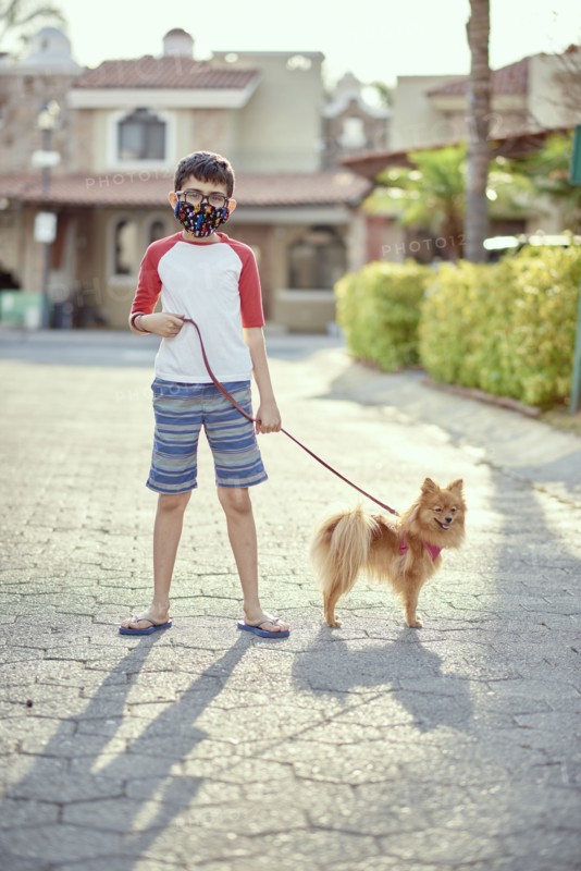 Mexico, Zapopan, Boy with face mask walking dog