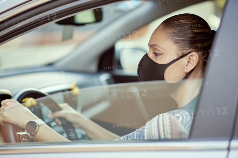 Woman with face mask driving car