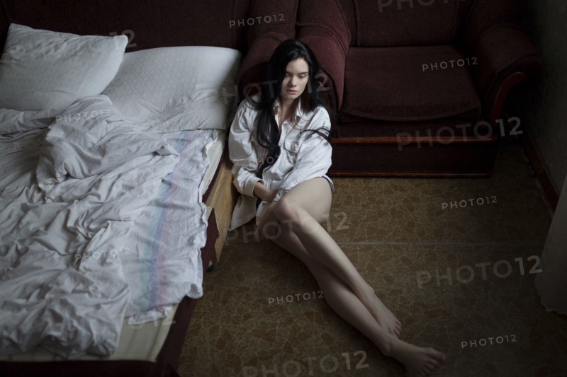 Semi-dress woman sitting on floor in bedroom