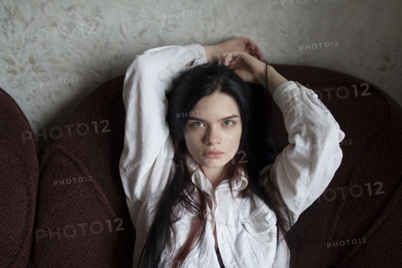 Portrait of young woman sitting in armchair