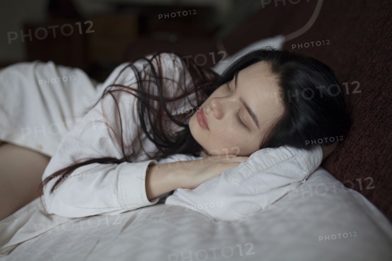 Young woman lying on bed