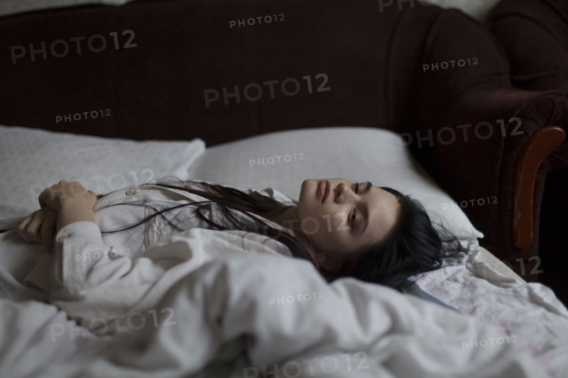 Young woman lying on bed