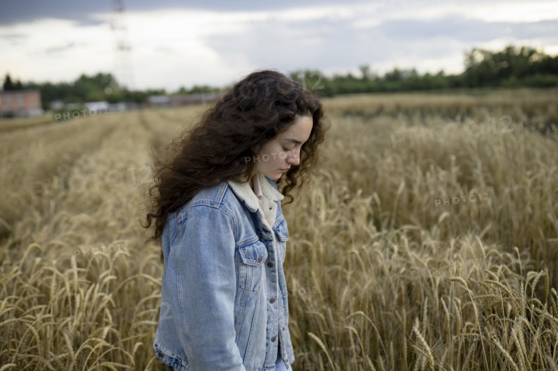 Russia, Omsk, Young woman standing in wheat field