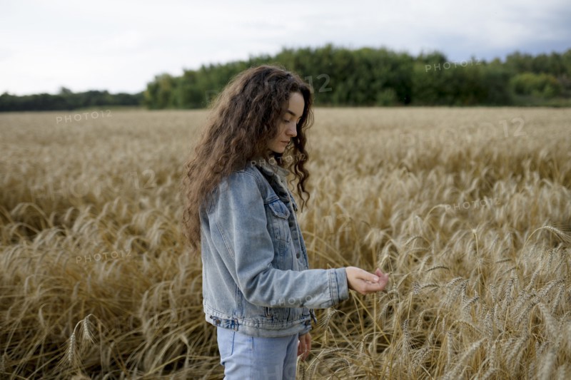 Russia, Omsk, Young woman standing in wheat field