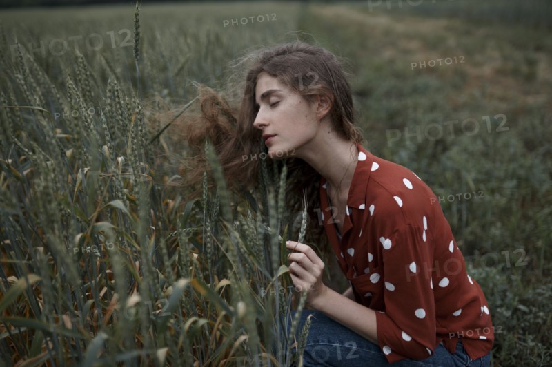 Russia, Omsk, Young women contemplating crops in field