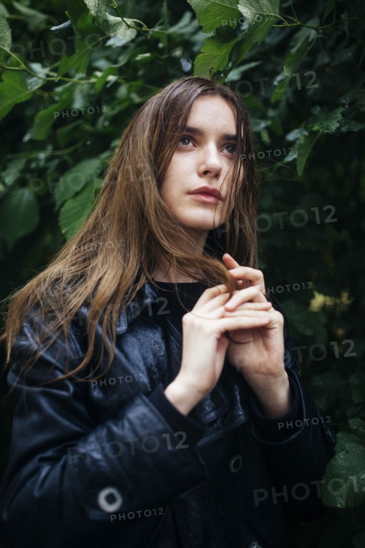 Portrait of young woman standing by tree