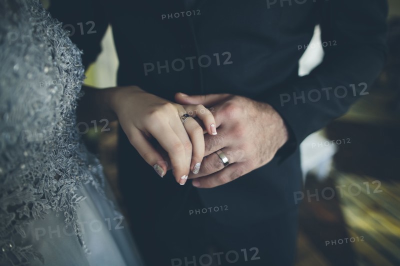 Close up of hands of bride and groom wearing wedding ring