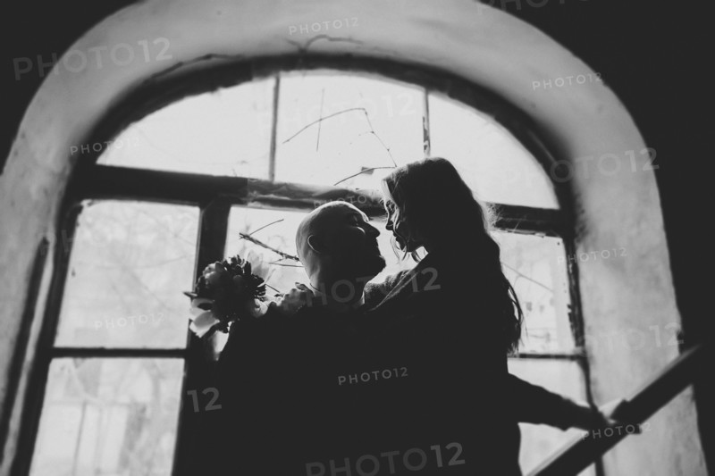 Newlywed couple embracing in window