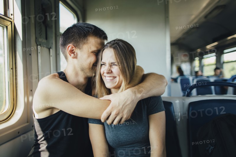 Young couple embracing in train
