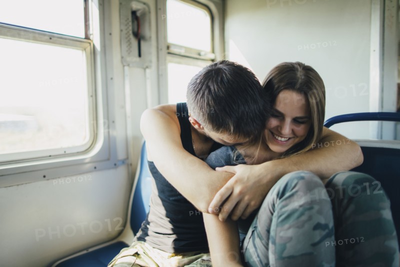 Young couple embracing in train