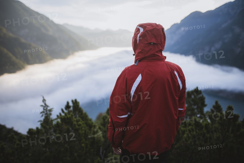 Austria, Plansee, Rear view of man in red jacket standing in Austrian Alps