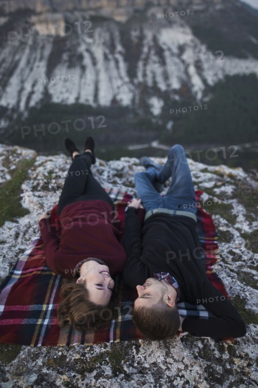 Ukraine, Crimea, Young couple lying down at plaid near canyon