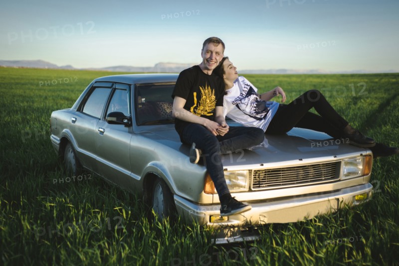 Ukraine, Crimea, Couple sitting on old fashioned car in rural scenery