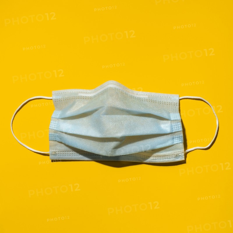 Surgical mask on yellow background