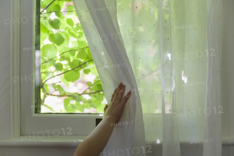 Girl (6-7) opening curtain