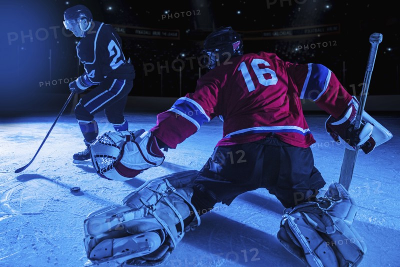 Hockey goalie in defensive position against forward