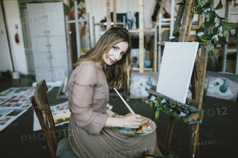 Woman painting on canvas in art studio