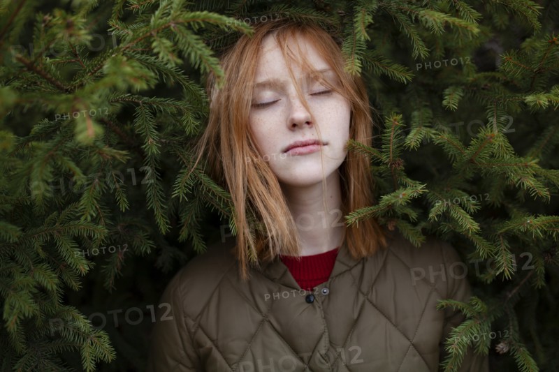Portrait of young woman in foliage