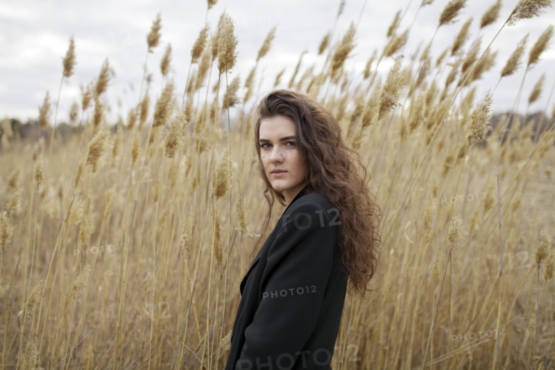 Russia, Omsk, Portrait of young woman in tall grass