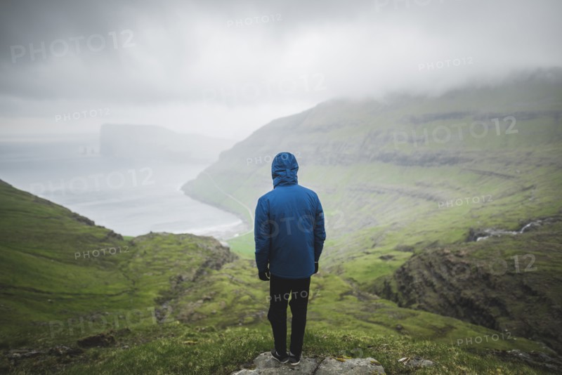 Denmark, Man standing on cliff above sea and looking at view,