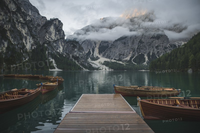 Italy, Wooden boats moored by pier at Pragser Wildsee in Dolomites,