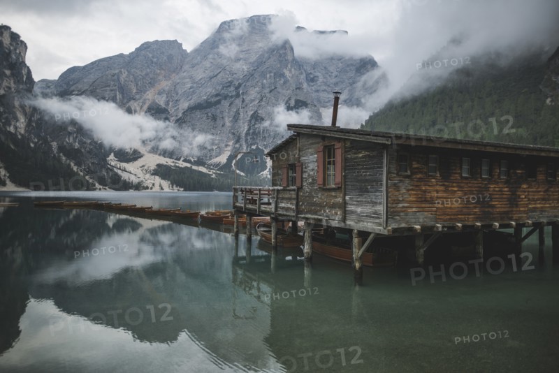 Italy, Wooden hut and boats at Pragser Wildsee in Dolomites,