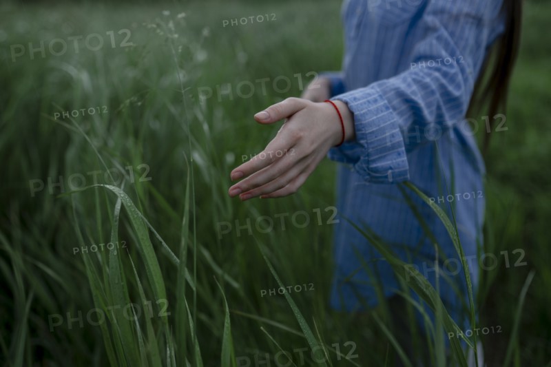 Russia, Omsk, Mid section of woman in tall grass