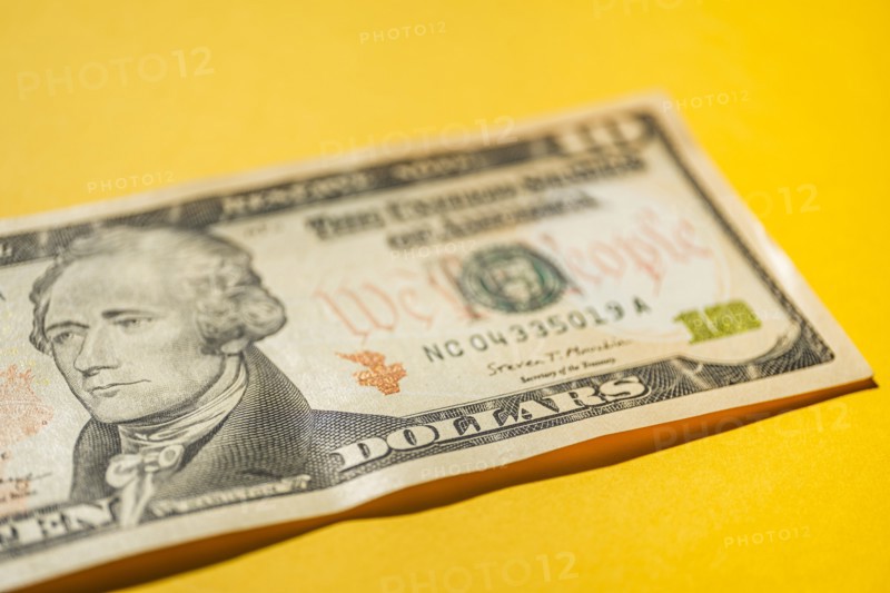 Close-up of US ten dollar bill on yellow