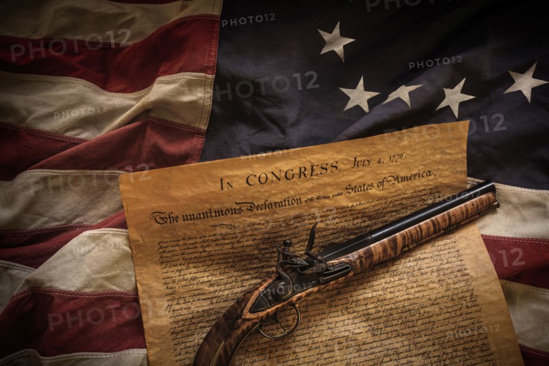 Flint and declaration of independence lying on American flag