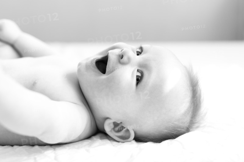 Smiling baby boy lying on bed