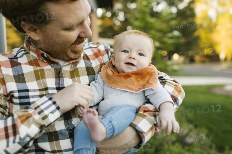 Father carrying baby boy outdoors