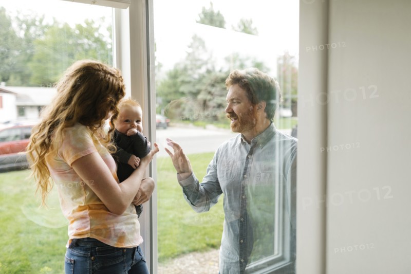Father visiting partner and son (6-11 months) through window
